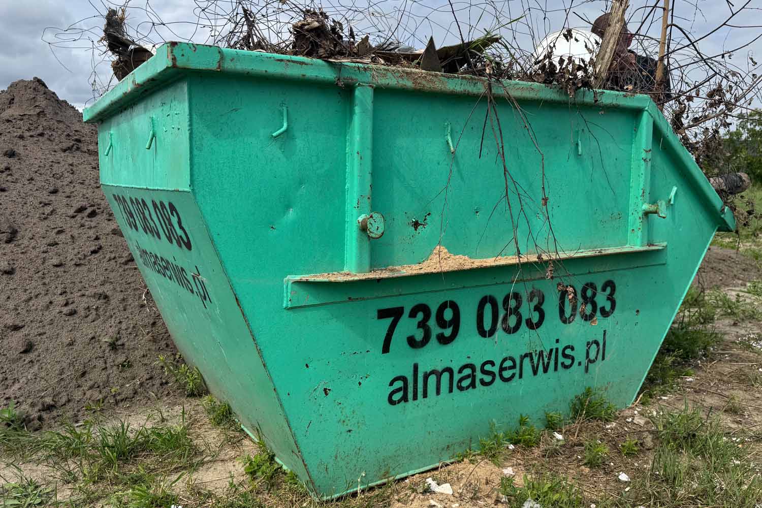 Kontener wypełniony gałęziami i odpadami z porządkowania terenu